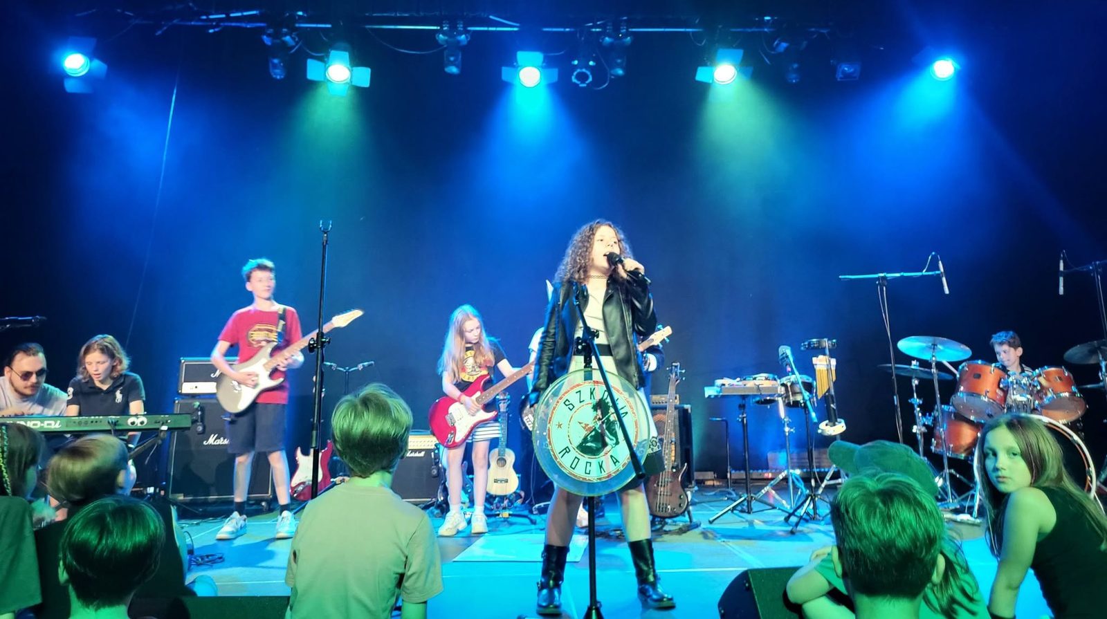 Zespół Szkoły Rocka podczas występu na scenie z widownią