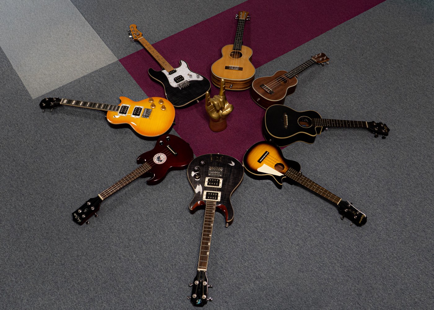 Gitary elektryczne, akustyczne i ukulele ułożone w gwiazdę na podłodze